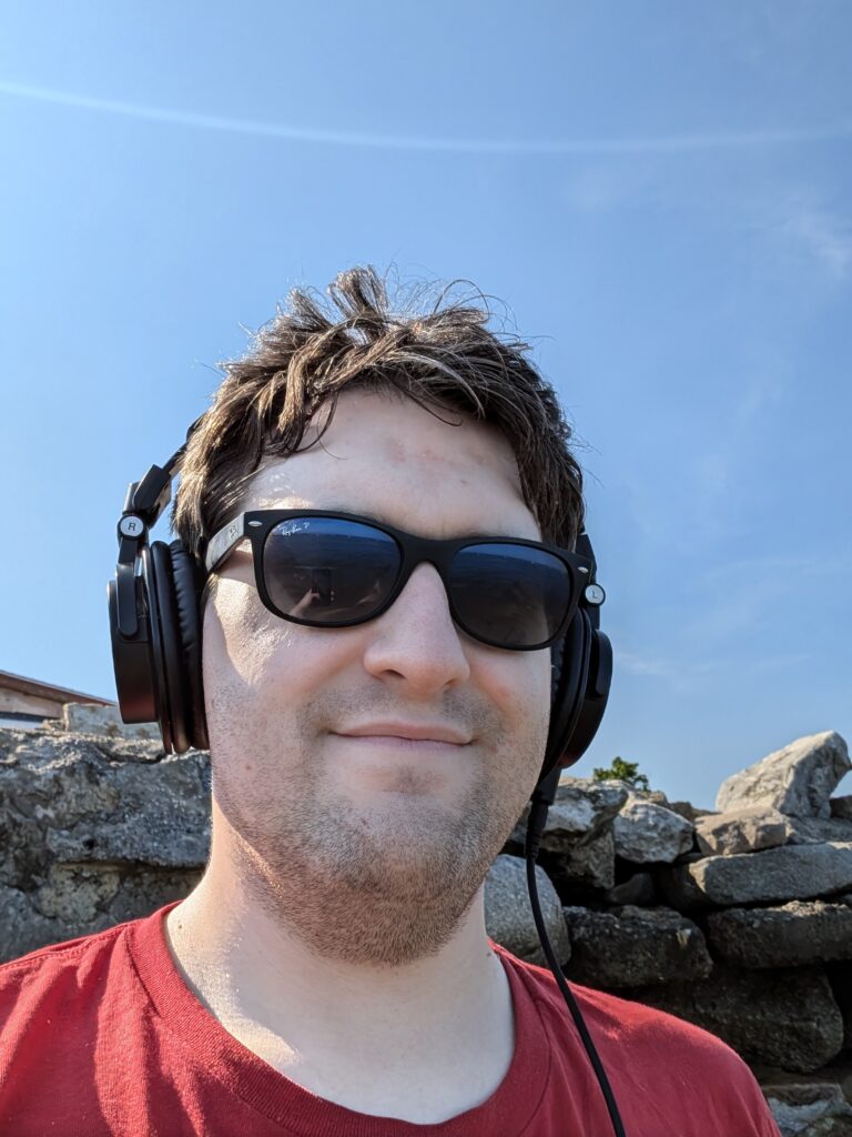 Myself, smiling, wearing sunglasses and studio headphones