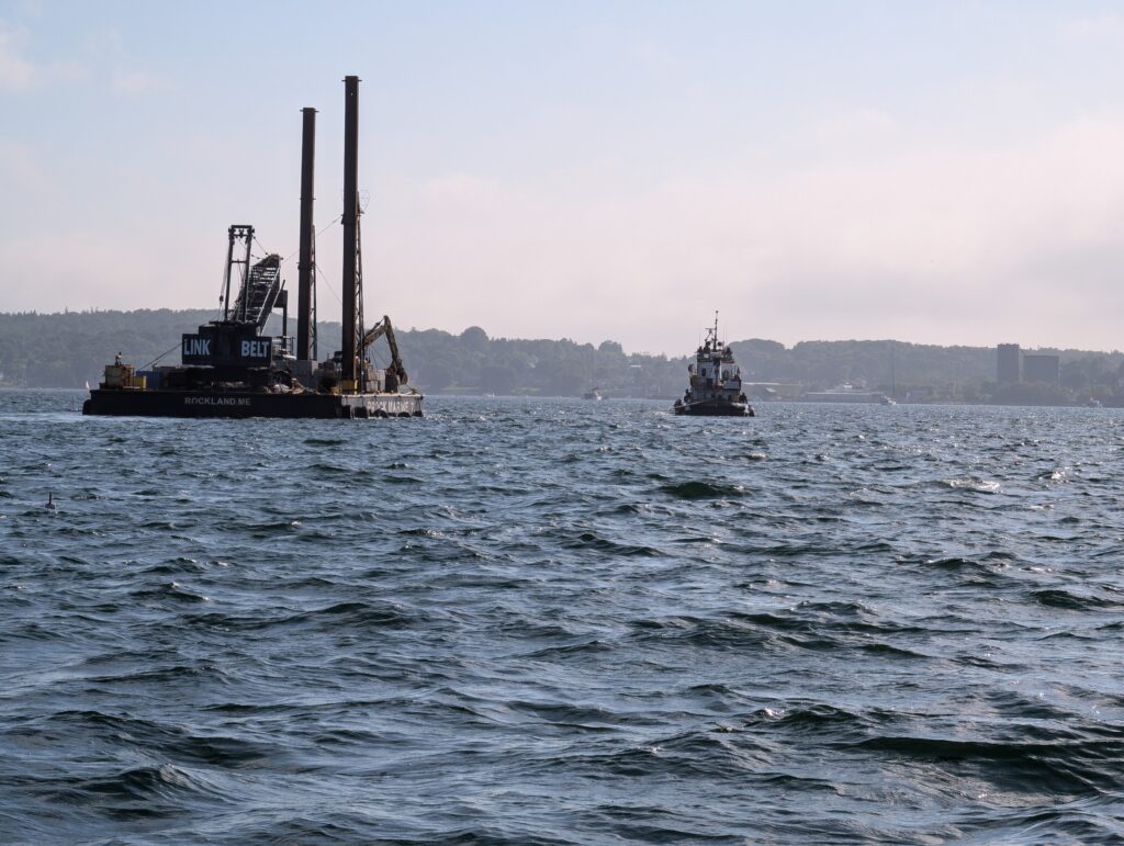 Big ship carrying construction equipment passing by.